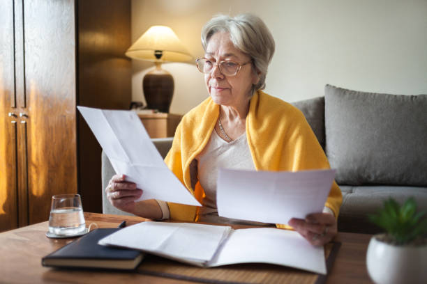istock Senior woman paying bills at home 2199624604