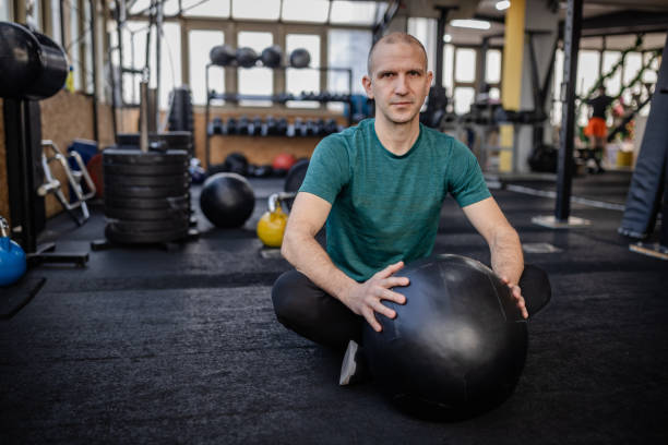 istock Man training with a stability ball in a modern gym, focusing on strength and endurance exercises for a healthy lifestyle 2199625465