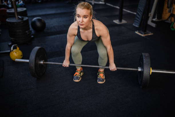 istock Strong woman lifting weights in gym while focused on strength training and fitness progress 2199630837