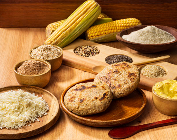 Studio shot of whole wheat arepa with healthy ingredients as  chia, sesame, quinoa, oats flakes, wheat bran, butter, grated white cheese and corn flour. These ingredients are mixed together except the butter and the white cheese to make the arepa dough and then cooked.
