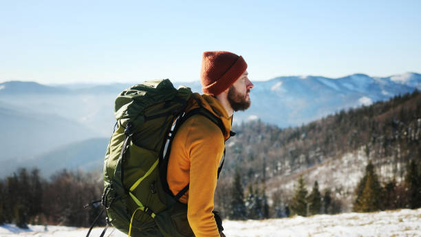 istock Adventurous Man Hiking Through Snowy Mountains on a Sunny Day 2199632369