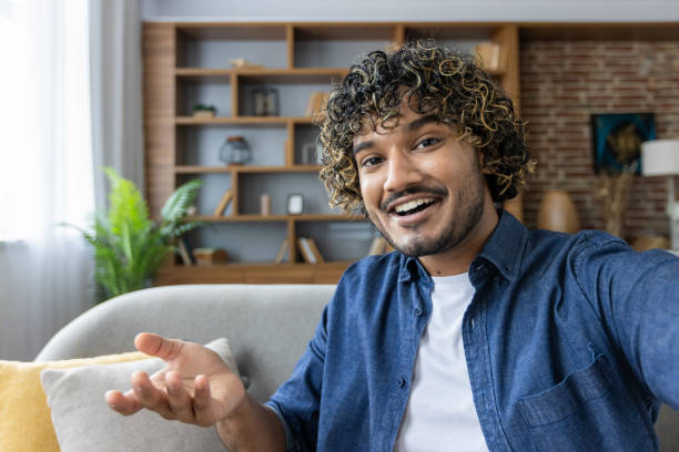 istock Smiling man taking a selfie in modern living room setting 2199632656