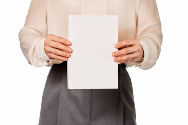 Male arm holding a Yellow hardcover book.