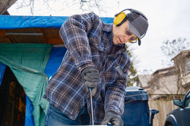 Senior man doing carpentry hobby project in his outdoor wood shop. Back yard of city residence in Toronto, Canada during winter with no snow.