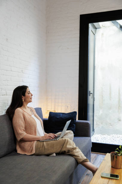 istock Woman relaxing at home with laptop on sofa 2199638377