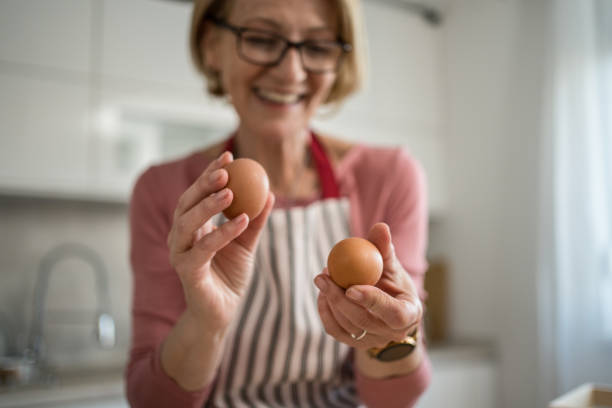 istock Middle-aged woman holding fresh eggs, smiling in modern kitchen 2199638908