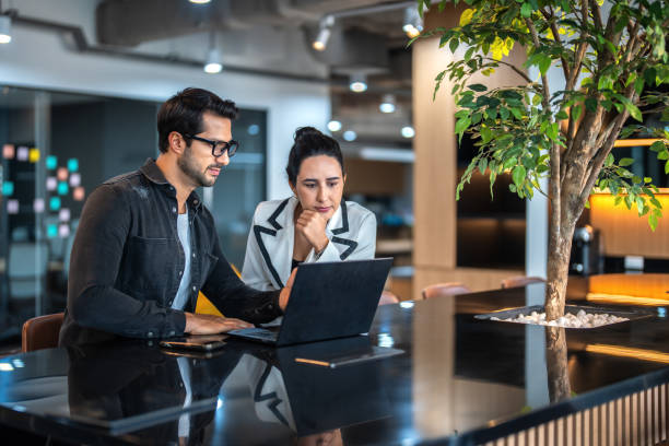 Business people working on a laptop in modern office.