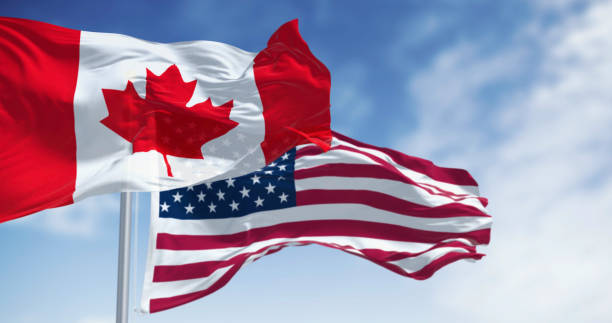 istock Canada and american national flags waving in the wind on a clear day 2199640659