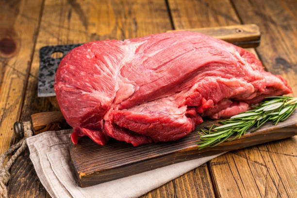 istock Fresh Raw Round Silverside beef meat cut, inside round with hrebs for roasting. wooden background. Top view 2199641630