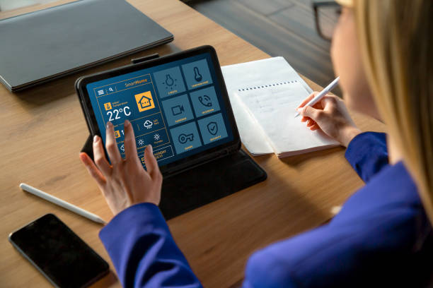 istock Woman Using Tablet with Smart Home App Displaying Temperature in Celsius 2199642098