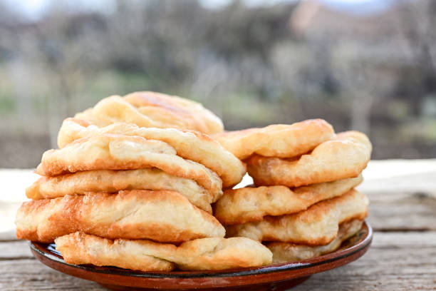 Traditional Bulgarian home made deep fried  patties  covered with sugar  оn rustic backgroud.Mekitsa or Mekica,  on wooden  rustic  background. Made of kneaded dough that is deep fried