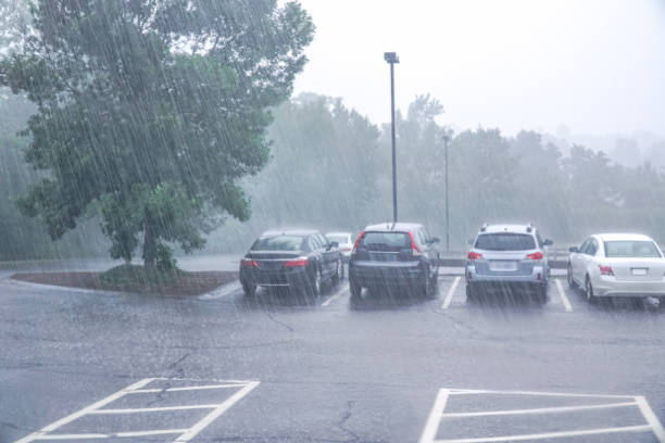 istock vehicles in parking lot in summer thunderstorm with heavy rain 2199649198