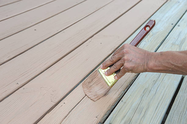 istock handyman painting the wooden deck with brush 2199650711