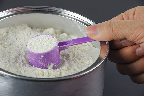 powder formula milk and purple spoon in finger