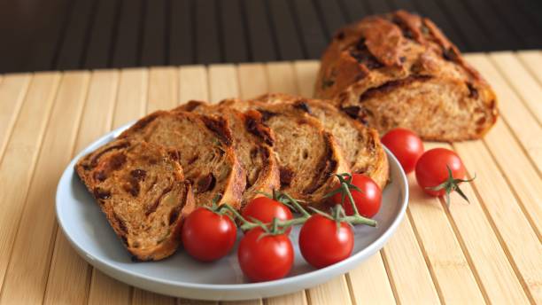 istock Bread with tomato and olives baked inside, served alongside bunch of fresh cherry tomatoes. Sourced directly from farm, diet-friendly dish is simple, clean, flavorful choice for healthy eating 2199653673