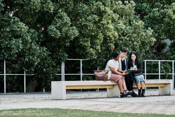 istock Group of professionals collaborating on digital tablet on bench 2199655105