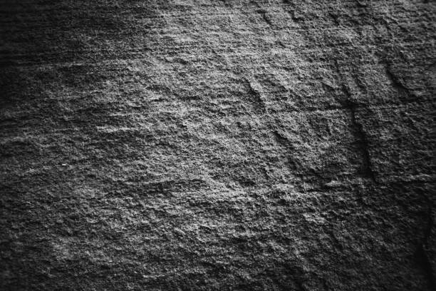 Monochrome black and white bumpy stone wall for abstract background and texture for interior or exterior design. Beautiful patterns, space for work, banner, wallpaper close up.