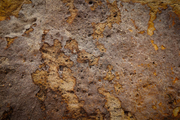 istock Brown grey rough stone wall with peeling of layer stone surface rusted cracks for abstract background and texture, interior or exterior design. Beautiful patterns, space for work, banner, close up. 2199661343