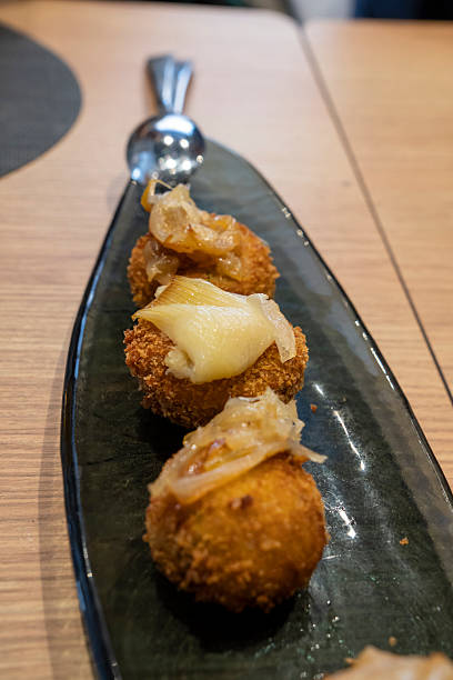 istock Three round croquettes with bacon on top on dark ceramic tray 2199662866