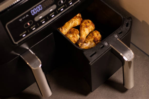 istock Close up an open black air fryer with roasted chicken drumsticks inside 2199666579