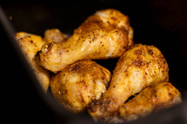 istock Close up an open black air fryer with roasted chicken drumsticks inside 2199666594