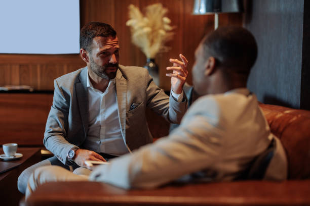 istock Businessmen having a conversation in a hotel lounge 2199672532