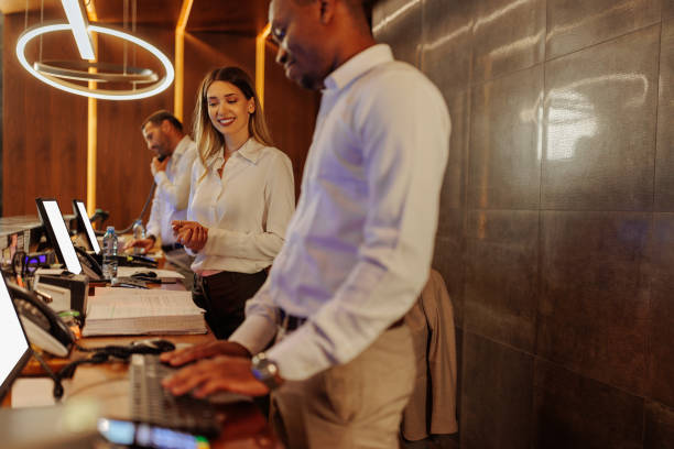 istock Hotel receptionist assisting guest at the front desk 2199672570