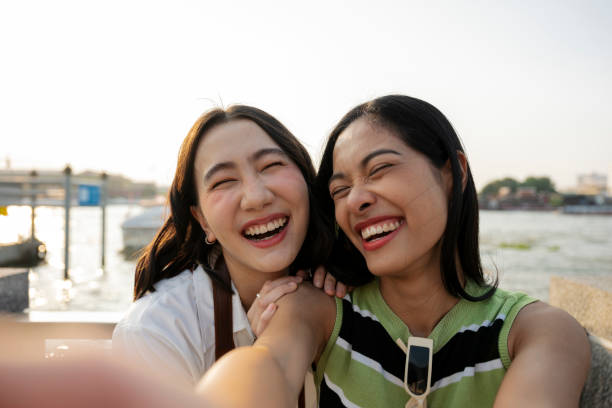 istock Two young women taking a selfie while laughing in bangkok 2199673779