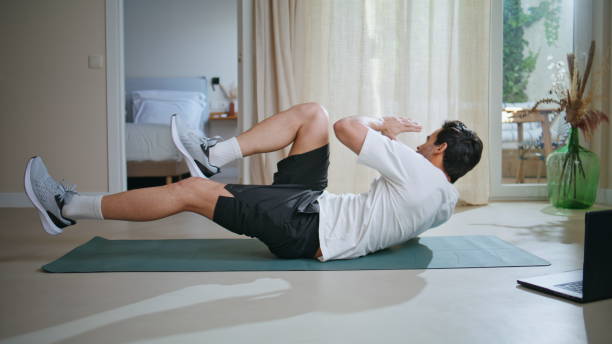 istock Sport man performing crunches on yoga mat home on workout. Active guy exercises 2199674538