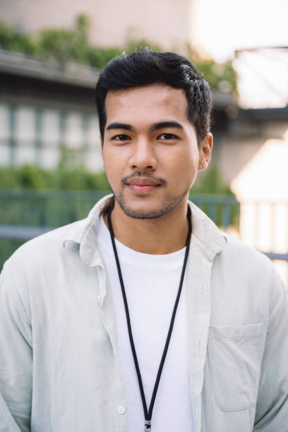istock Young asian man smiling and looking at camera in urban setting 2199676414