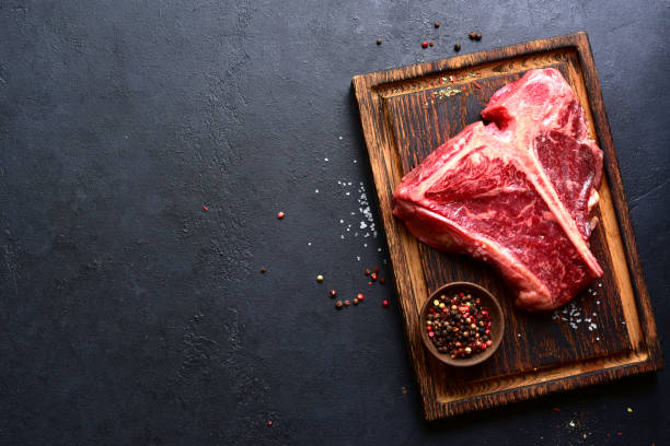istock Raw organic T-bone steak with spices . Top view with copy space. 2199677405