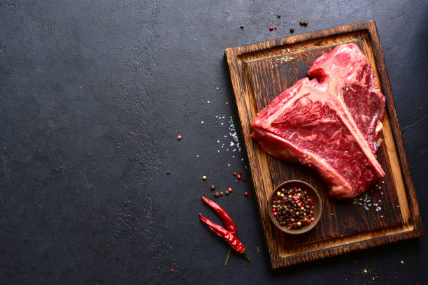 istock Raw organic T-bone steak with spices . Top view with copy space. 2199677621