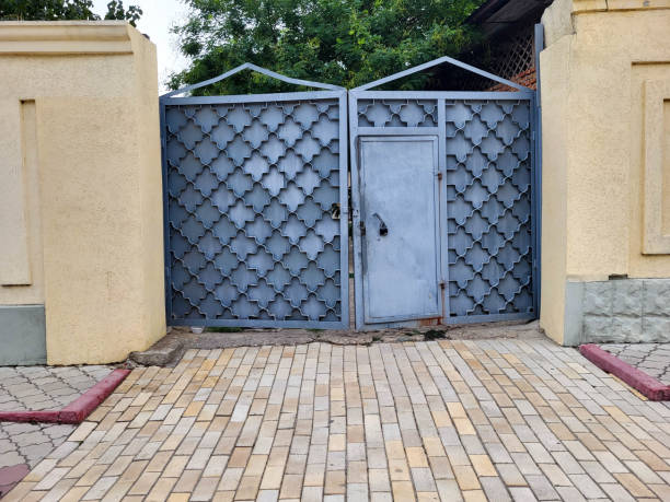istock There are grey iron gates with forged elements on the street. 2199683017
