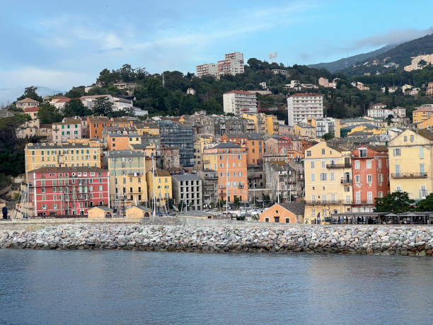 Vibrant seaside town with colorful buildings along the coast. Picturesque hill slopes with residences.