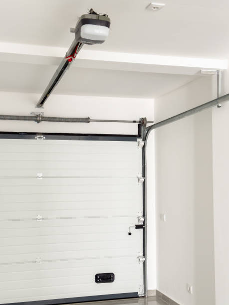 istock White automatic garage door with a motorized opener and metal support system. 2199687013