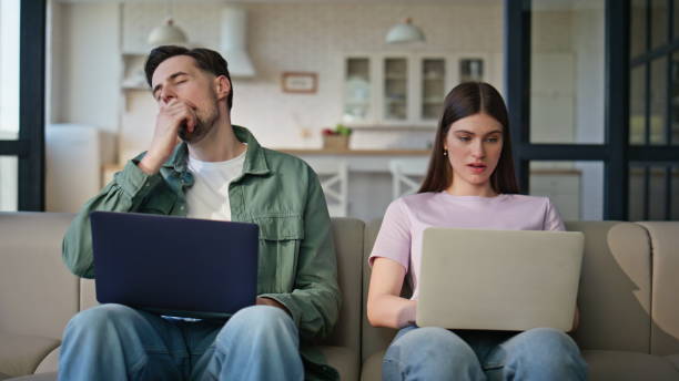 istock Online managers using computers at room interior closeup. Exhausted man yawning 2199689860