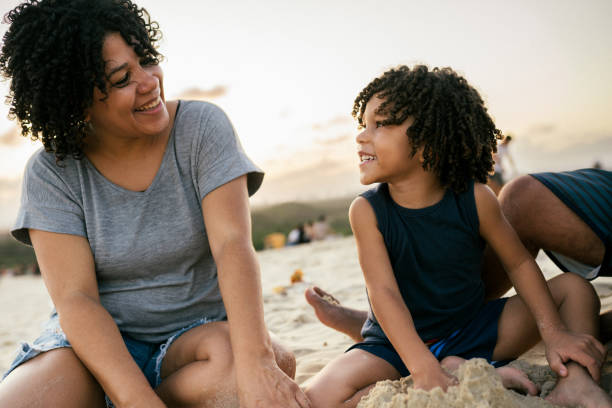 istock Smiling mother and child playing with the sand on a sand dune 2199692064