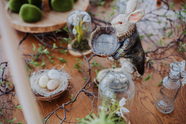Decorative bunny centerpiece with greenery and nest on wooden table