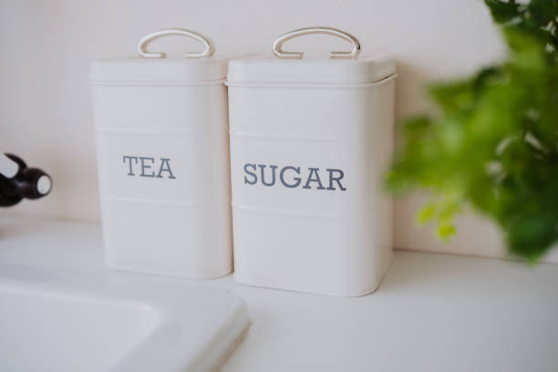 istock Storage containers for tea and sugar on a kitchen counter with greenery 2199700086