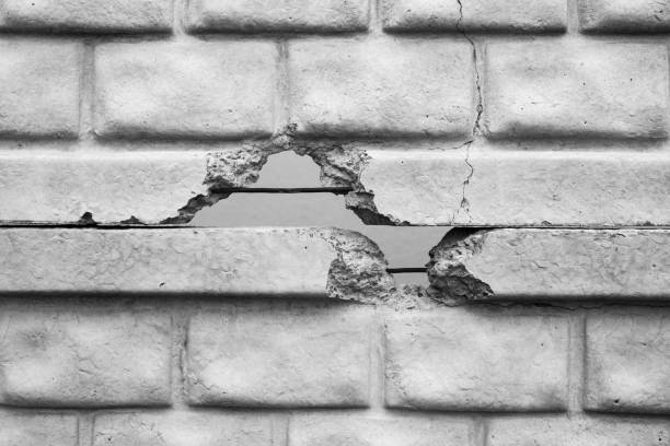 A wall shows significant cracking and a hole exposing what's behind it.