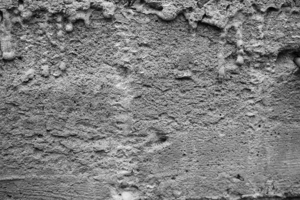 istock Textured concrete wall with varied surface patterns and shades of gray 2199700156