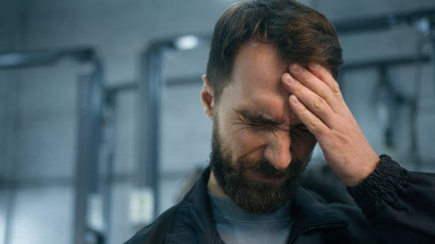 istock Close up Caucasian ill sick unwell man mechanic technical engineer automotive industry worker working hard at auto car truck service suffer headache feeling bad migraine overworked painful head ache 2199702856