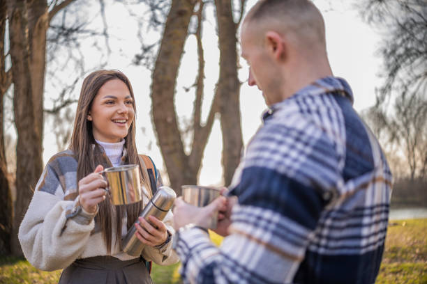 istock Happy couple  resting of a hiking on the mountain while talking and drinking coffee. 2199705590