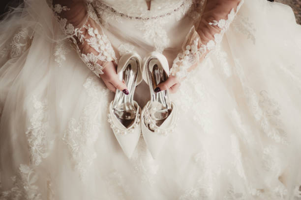 High angle photo of woman getting dressed for wedding with shoes on her lap