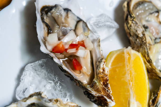 istock raw oysters with vegetable sauces and lemon slices 2199722161