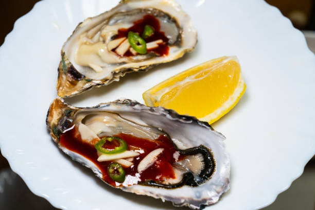 istock raw oysters with sauces and lemon slice on the table 2199722342