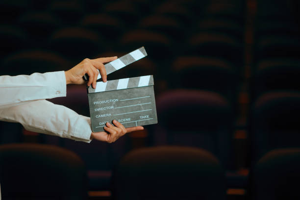 istock Hand Holding Clapperboard in a Movie Theater 2199730447