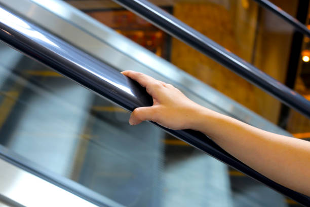 istock Hand holding escalator handrail in shopping mall or building 2199731907