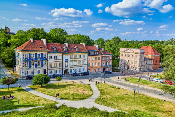 Line of multi colored old apartment blocks with many architectural features with public park area near the old heritage town centre of Warsaw, Poland, Europe