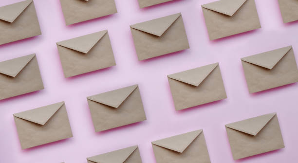 Kraft brown paper envelopes on pink background